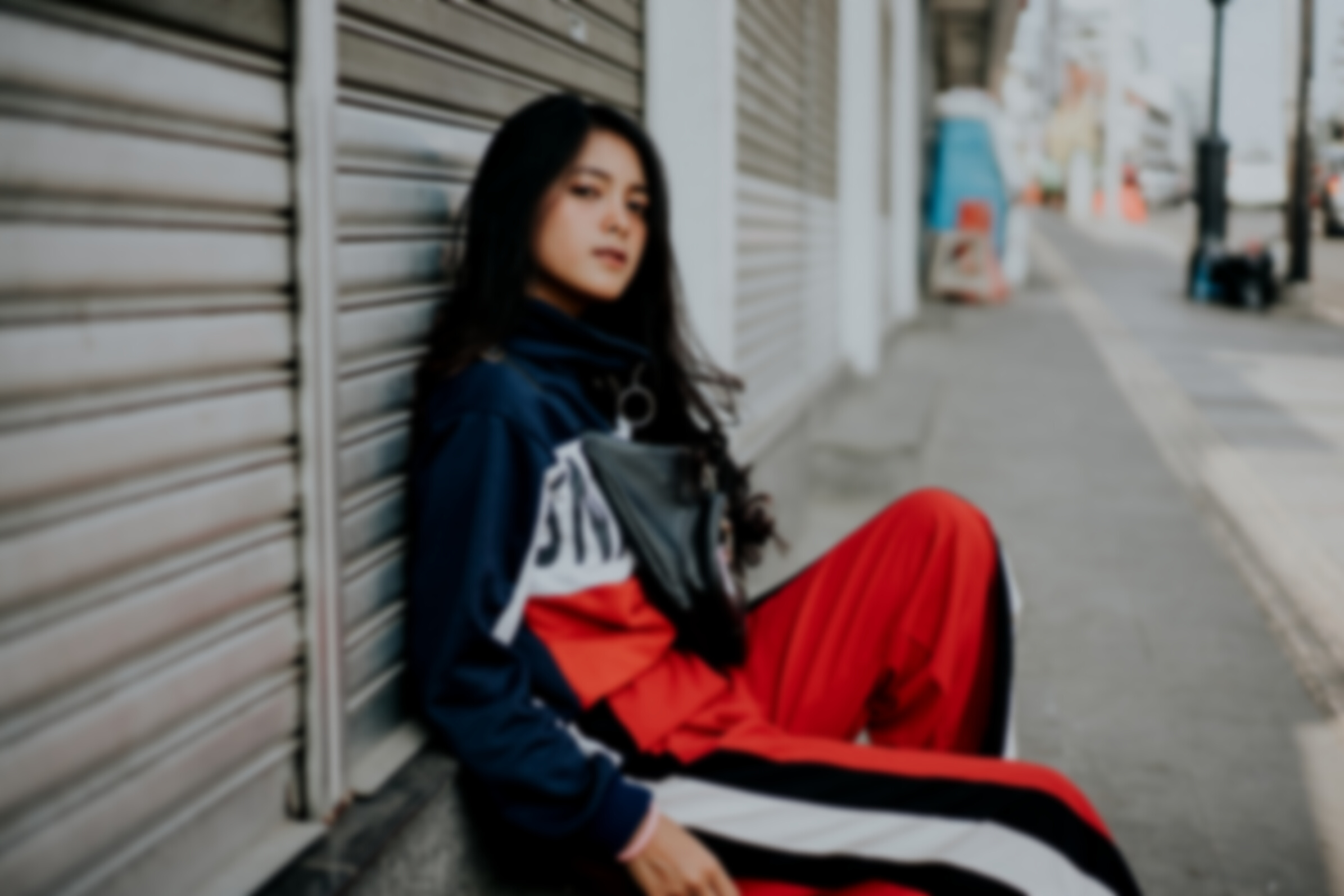 Woman in Blue and Red Jacket Sitting on Gray Concrete Stairs
